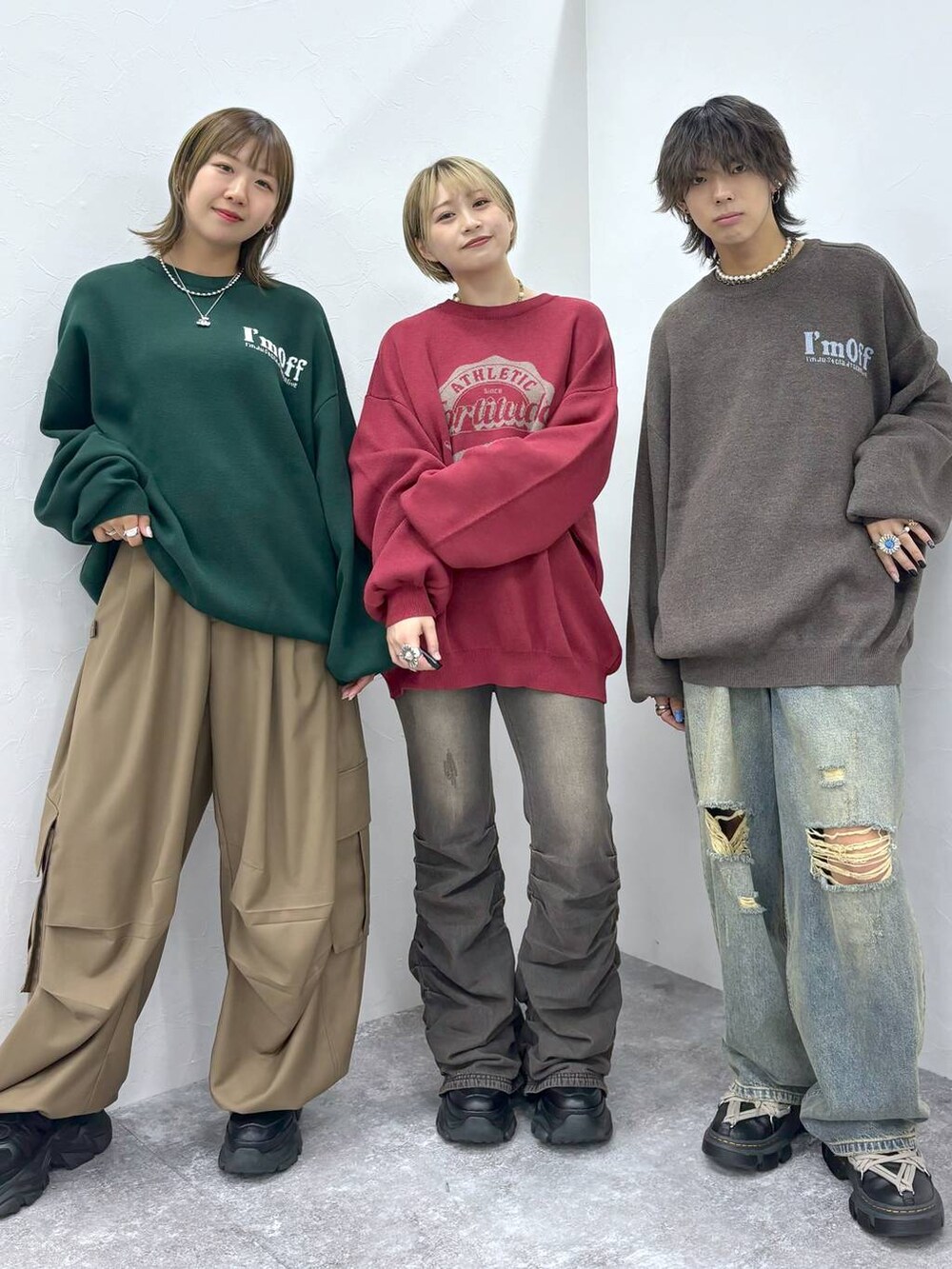 ブラック系のスニーカー、ブラック系のデニムパンツ、レッド系のニット/セーターを着用したレディースの秋コーディネートの3枚目の写真