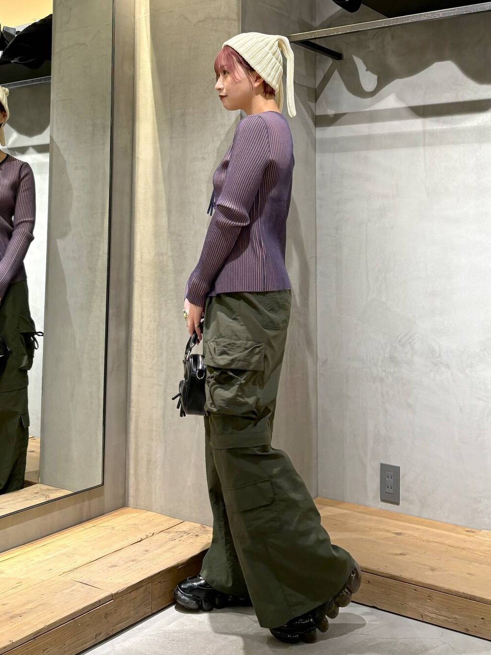 ブルー系のニット/セーター、ブラック系のボストンバッグ、グリーン系のカーゴパンツを着用したレディースの冬コーディネートの5枚目の写真