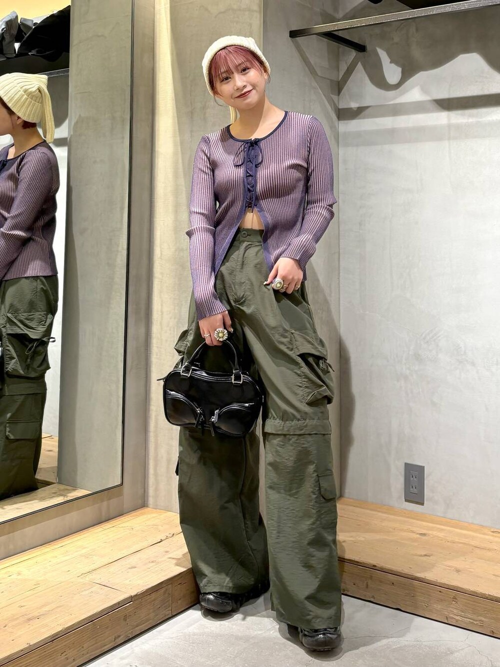 ブルー系のニット/セーター、ブラック系のボストンバッグ、グリーン系のカーゴパンツを着用したレディースの冬コーディネートの2枚目の写真