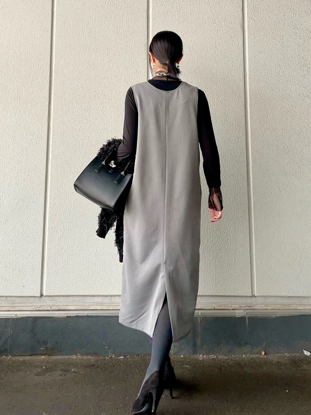グレー系のワンピース、ブラック系のカーディガン/ボレロ、ブラック系のショルダーバッグを着用したレディースの冬コーディネートの5枚目の写真