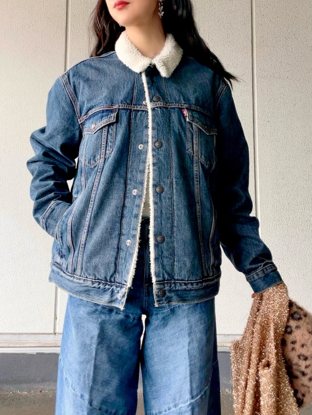 ブルー系のデニムジャケット、ブルー系のデニムパンツ、ブラック系のブーツを着用したレディースの冬コーディネートの5枚目の写真