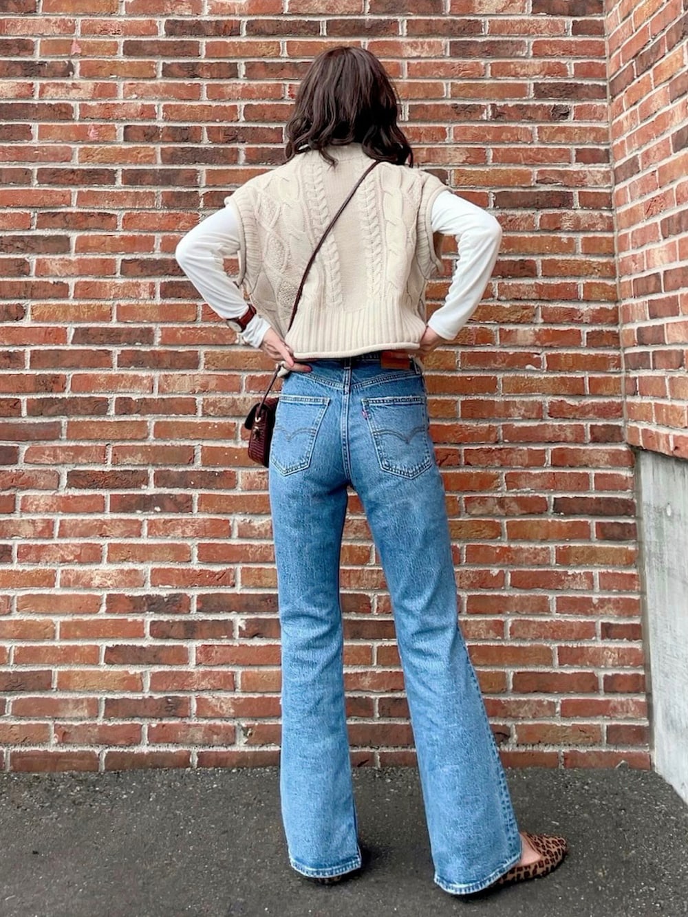 ホワイト系のベスト、ホワイト系のTシャツ/カットソー、ブルー系のデニムパンツを着用したレディースの秋コーディネートの3枚目の写真