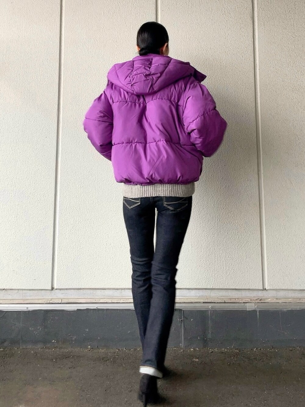 グレー系のニット/セーター、パープル系のブルゾン、ブルー系のデニムパンツを着用したレディースの冬コーディネートの3枚目の写真