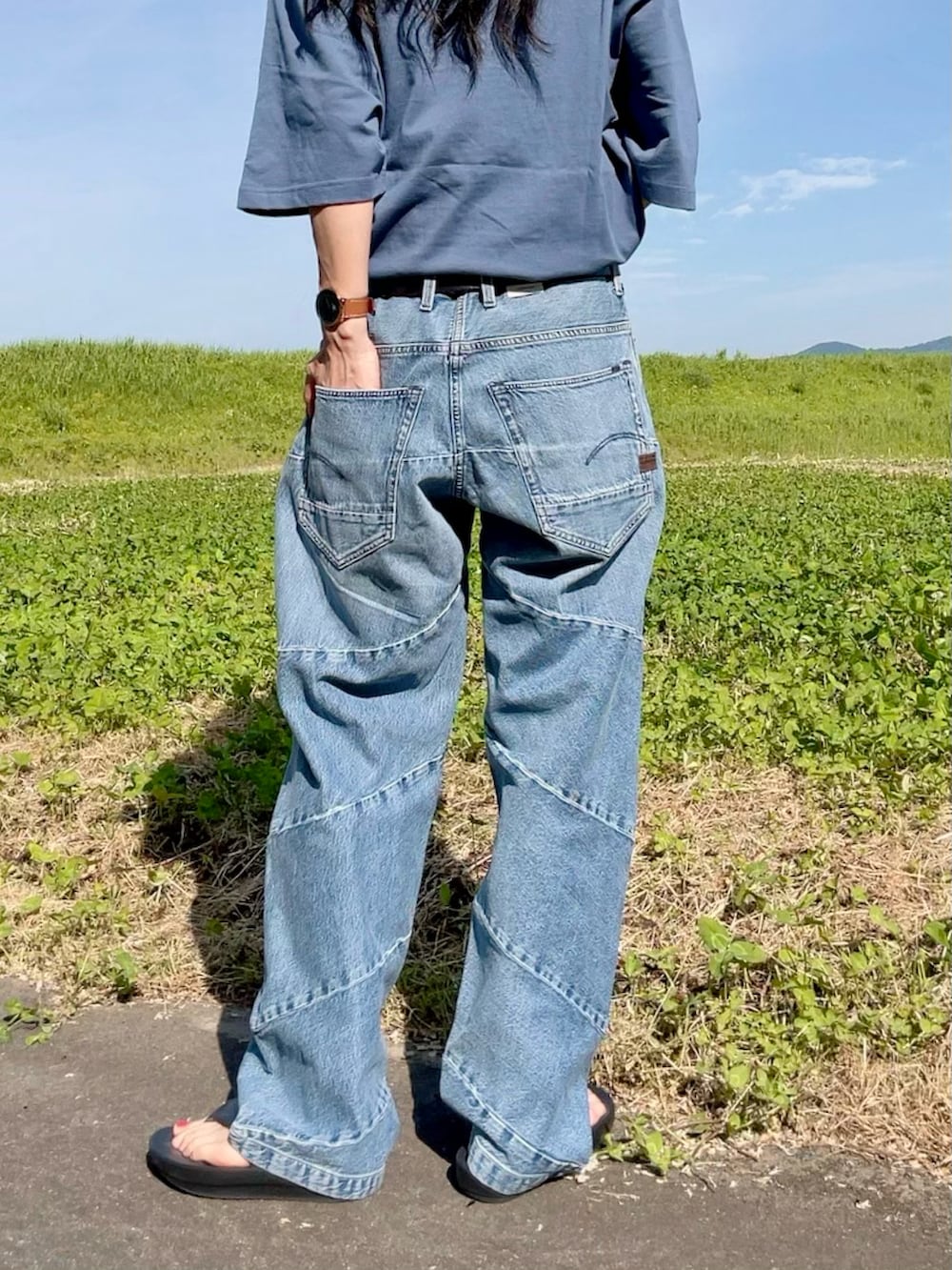 ブルー系のTシャツ/カットソー、ブルー系のデニムパンツ、ブラック系のサンダルを着用したレディースの夏コーディネートの2枚目の写真