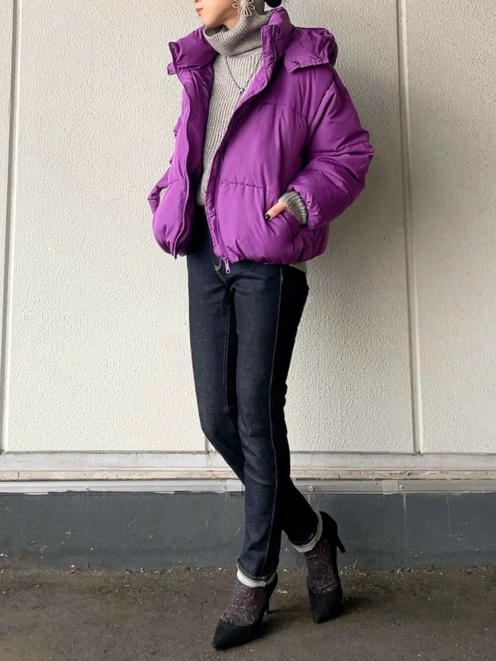 グレー系のニット/セーター、パープル系のブルゾン、ブルー系のデニムパンツを着用したレディースの冬コーディネートの2枚目の写真