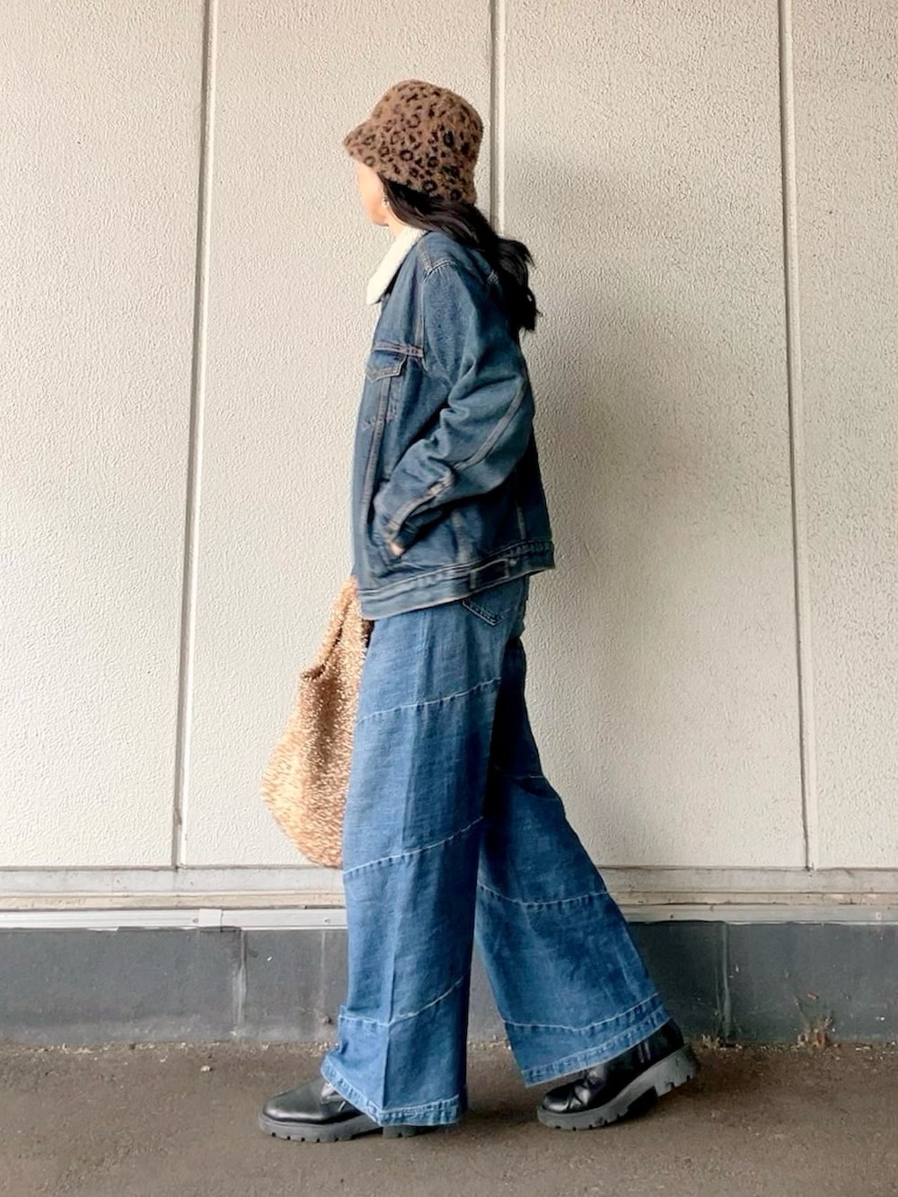 ブルー系のデニムジャケット、ブルー系のデニムパンツ、ブラック系のブーツを着用したレディースの冬コーディネートの2枚目の写真