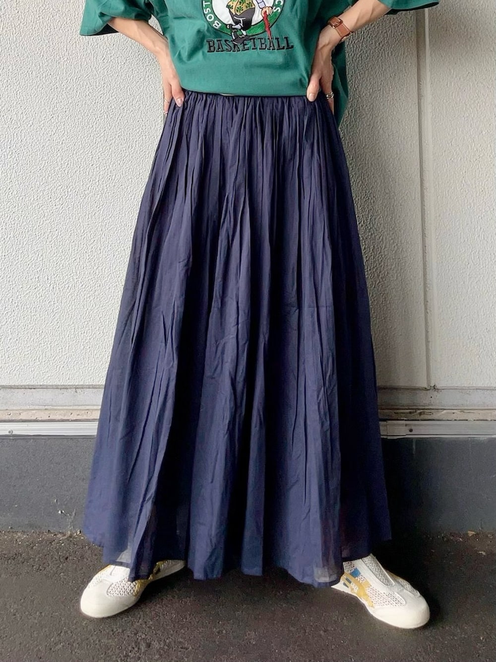 グリーン系のTシャツ/カットソー、ブルー系のスカート、イエロー系のエコバッグ/サブバッグを着用したレディースの夏コーディネートの4枚目の写真