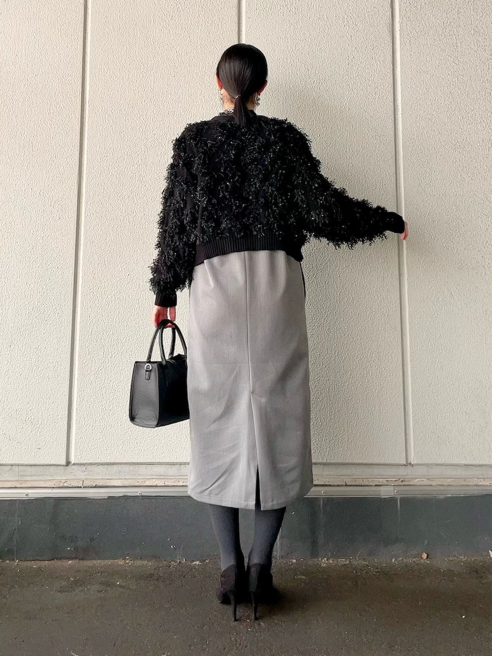 グレー系のワンピース、ブラック系のカーディガン/ボレロ、ブラック系のショルダーバッグを着用したレディースの冬コーディネートの4枚目の写真