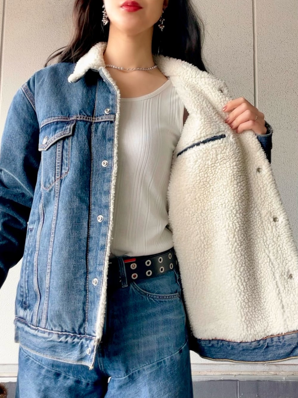 ブルー系のデニムジャケット、ブルー系のデニムパンツ、ブラック系のブーツを着用したレディースの冬コーディネートの7枚目の写真