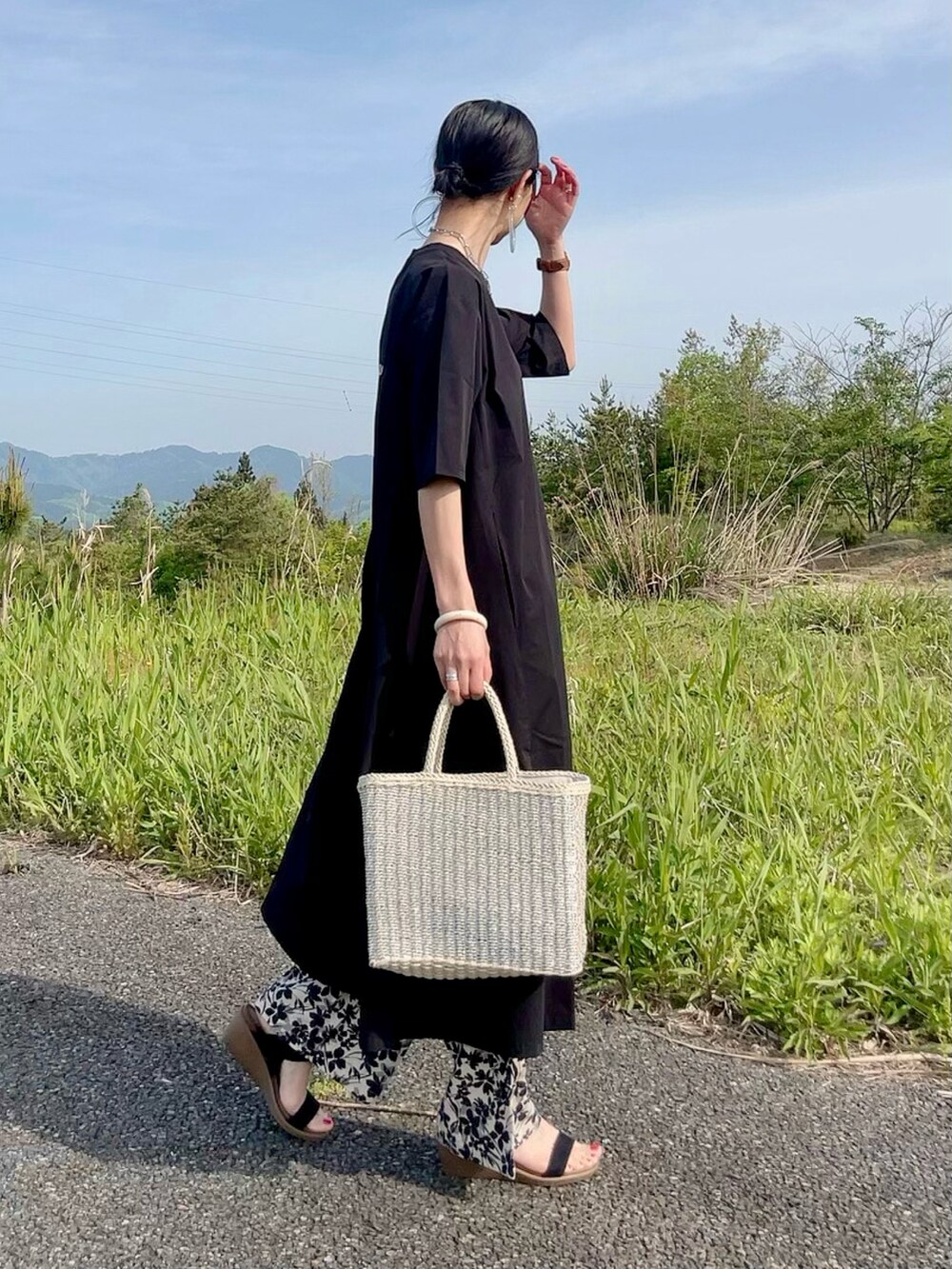 ブラック系のワンピース、ベージュ系のその他パンツ、シルバー系のかごバッグを着用したレディースの夏コーディネートの2枚目の写真