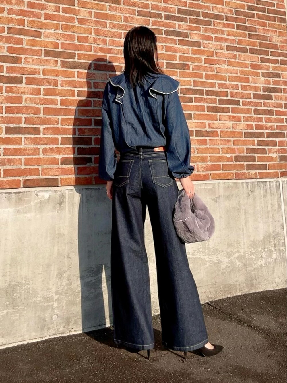 ブルー系のシャツ/ブラウス、ブルー系のデニムパンツ、グレー系のハンドバッグを着用したレディースの秋コーディネートの3枚目の写真