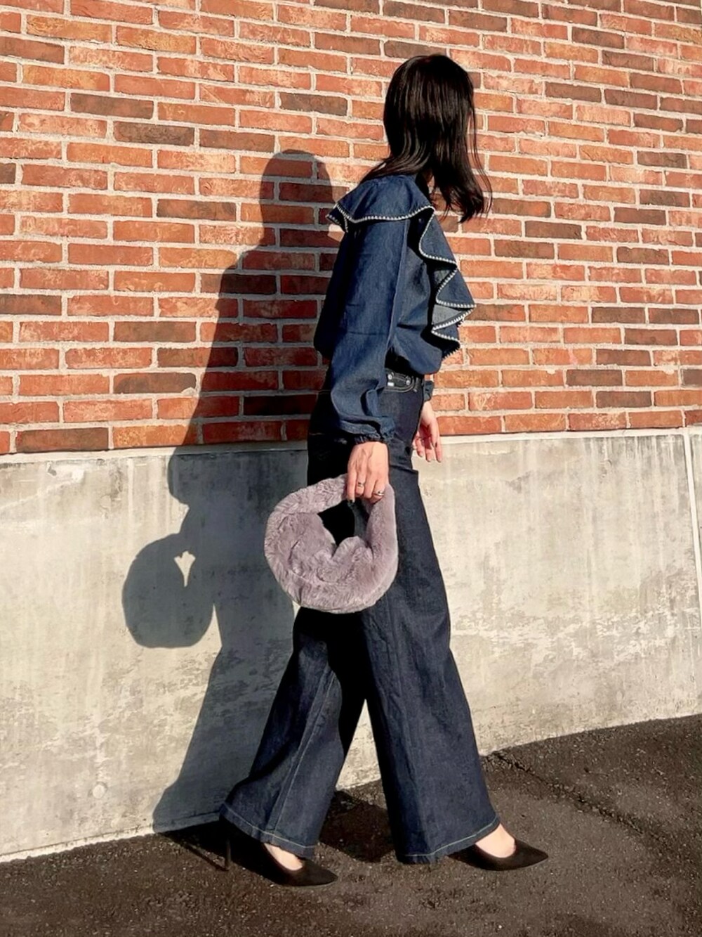 ブルー系のシャツ/ブラウス、ブルー系のデニムパンツ、グレー系のハンドバッグを着用したレディースの秋コーディネートの2枚目の写真