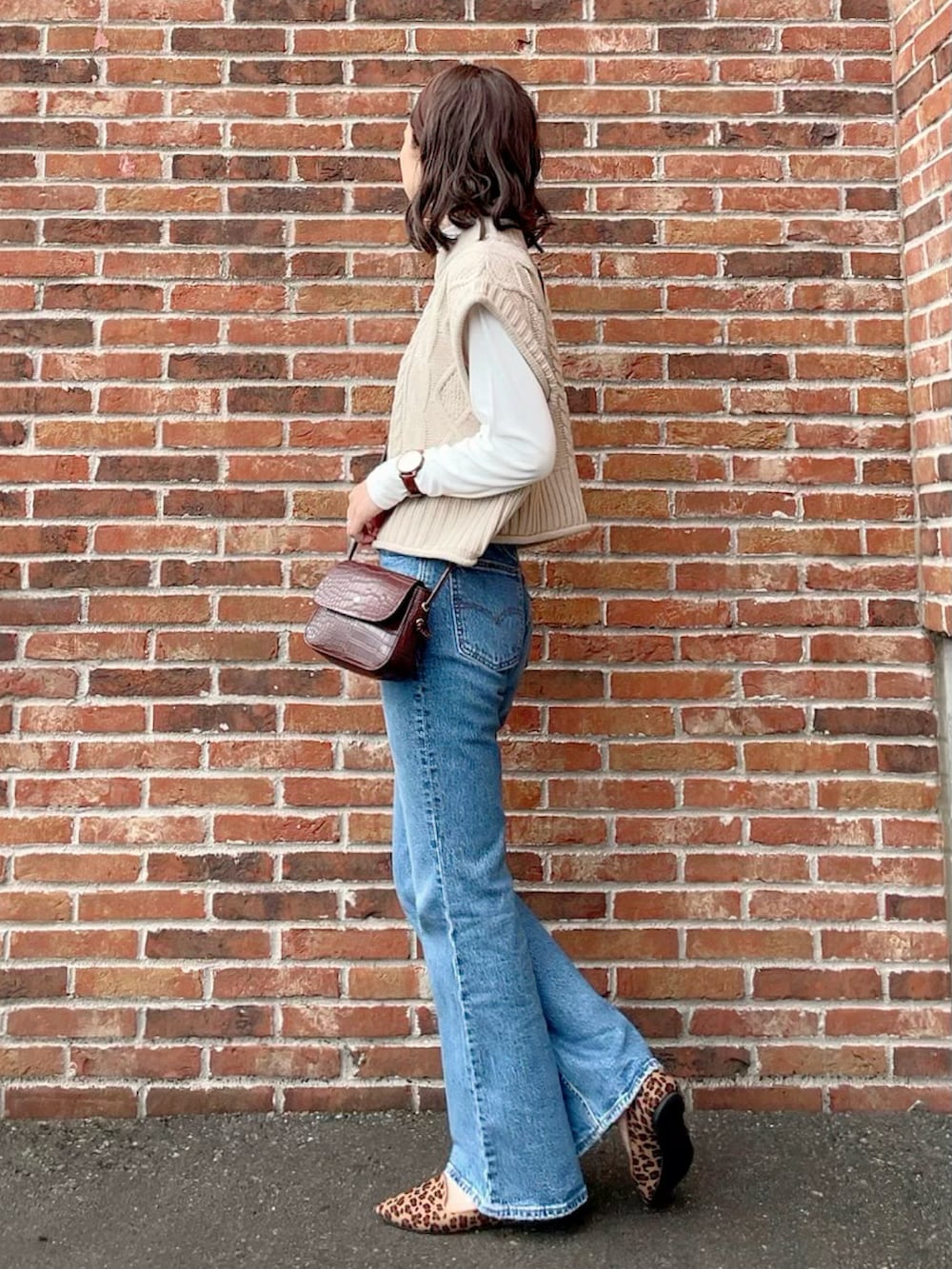 ホワイト系のベスト、ホワイト系のTシャツ/カットソー、ブルー系のデニムパンツを着用したレディースの秋コーディネートの2枚目の写真