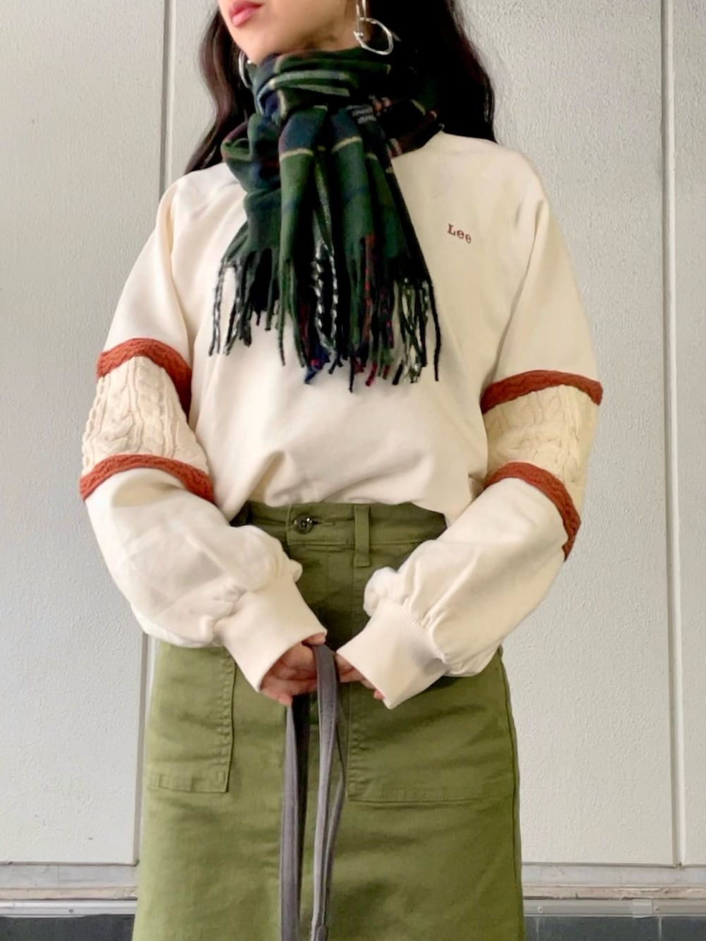 ホワイト系のスウェット、グリーン系のスカート、グレー系のショルダーバッグを着用したレディースの冬コーディネートの5枚目の写真