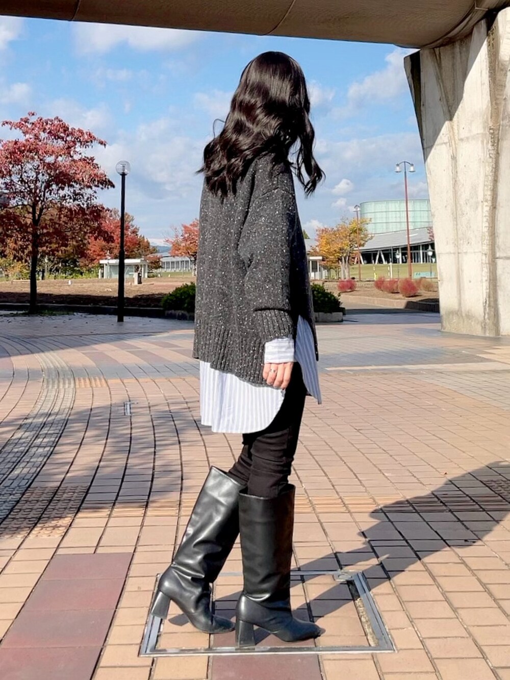 グレー系のニット/セーター、ブルー系のシャツ/ブラウス、ブラック系のデニムパンツを着用したレディースの冬コーディネートの4枚目の写真