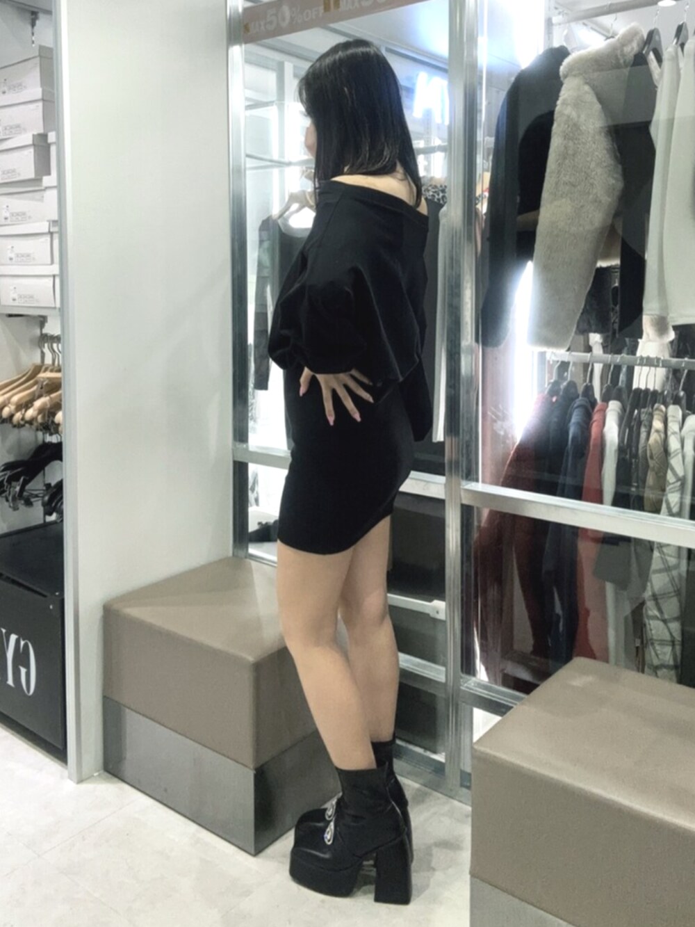 ブラック系のワンピース、ブラック系のブーツを着用したレディースの冬コーディネートの2枚目の写真