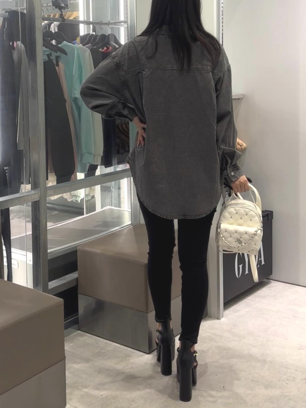 ブラック系のシャツ/ブラウス、ブラック系のデニムパンツ、ホワイト系のバックパック/リュックを着用したレディースの春コーディネートの3枚目の写真