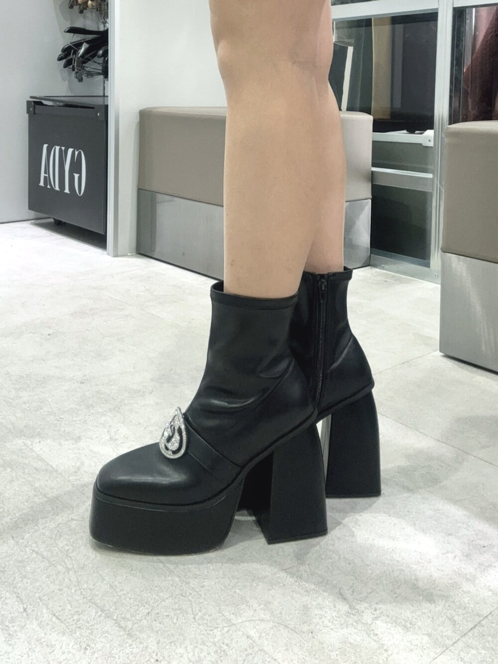 ブラック系のワンピース、ブラック系のブーツを着用したレディースの冬コーディネートの5枚目の写真