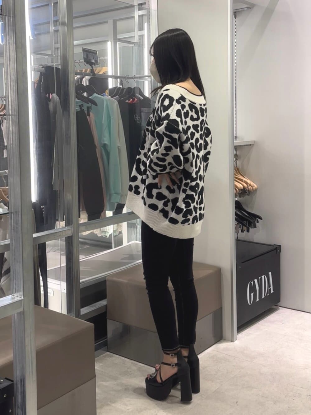 ブラック系のデニムパンツ、ブラック系のサンダル、ホワイト系のチューブトップを着用したレディースの春コーディネートの2枚目の写真