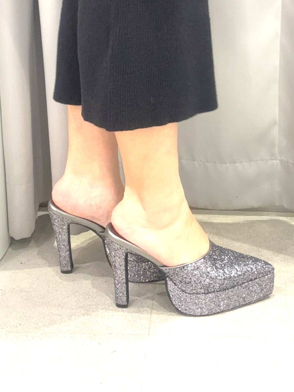 ブラック系のワンピース、ブルー系のデニムジャケット、グレー系のパンプスを着用したレディースの春コーディネートの6枚目の写真