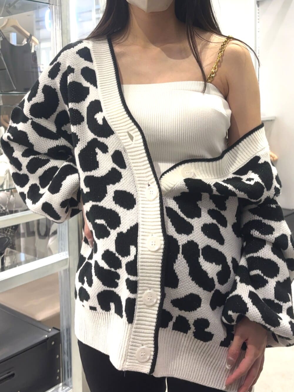 ブラック系のデニムパンツ、ブラック系のサンダル、ホワイト系のチューブトップを着用したレディースの春コーディネートの4枚目の写真