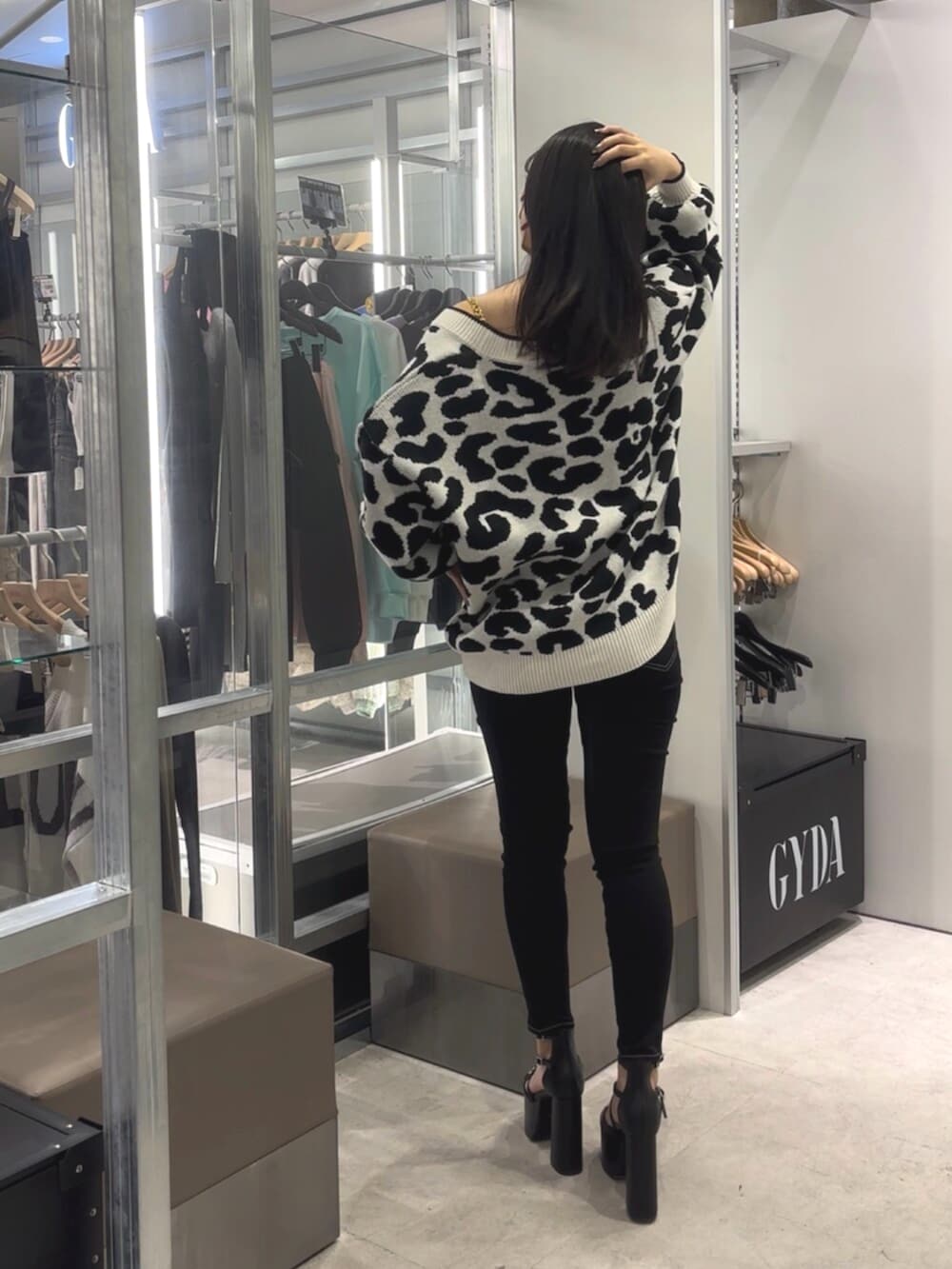 ブラック系のデニムパンツ、ブラック系のサンダル、ホワイト系のチューブトップを着用したレディースの春コーディネートの3枚目の写真