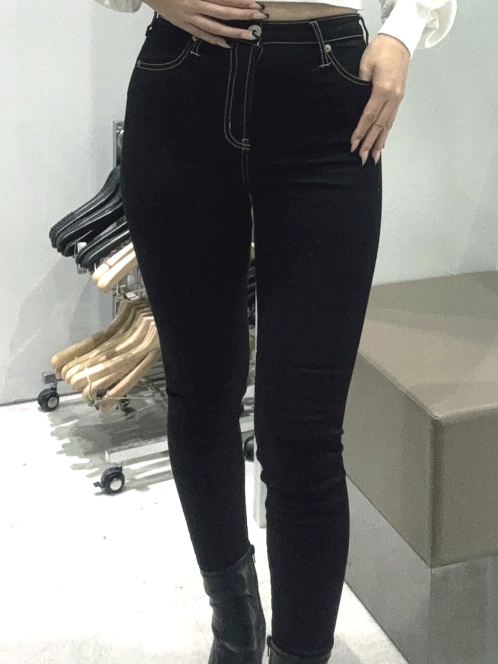 ブラック系のデニムパンツ、ブラック系のサンダル、ホワイト系のチューブトップを着用したレディースの春コーディネートの5枚目の写真