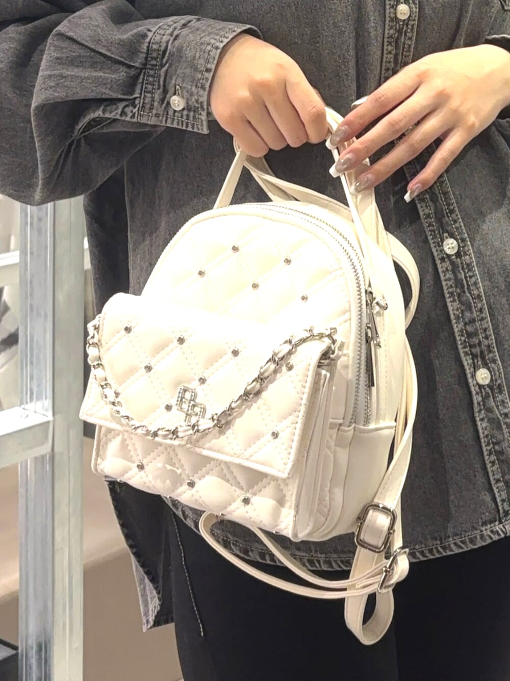 ブラック系のシャツ/ブラウス、ブラック系のデニムパンツ、ホワイト系のバックパック/リュックを着用したレディースの春コーディネートの5枚目の写真