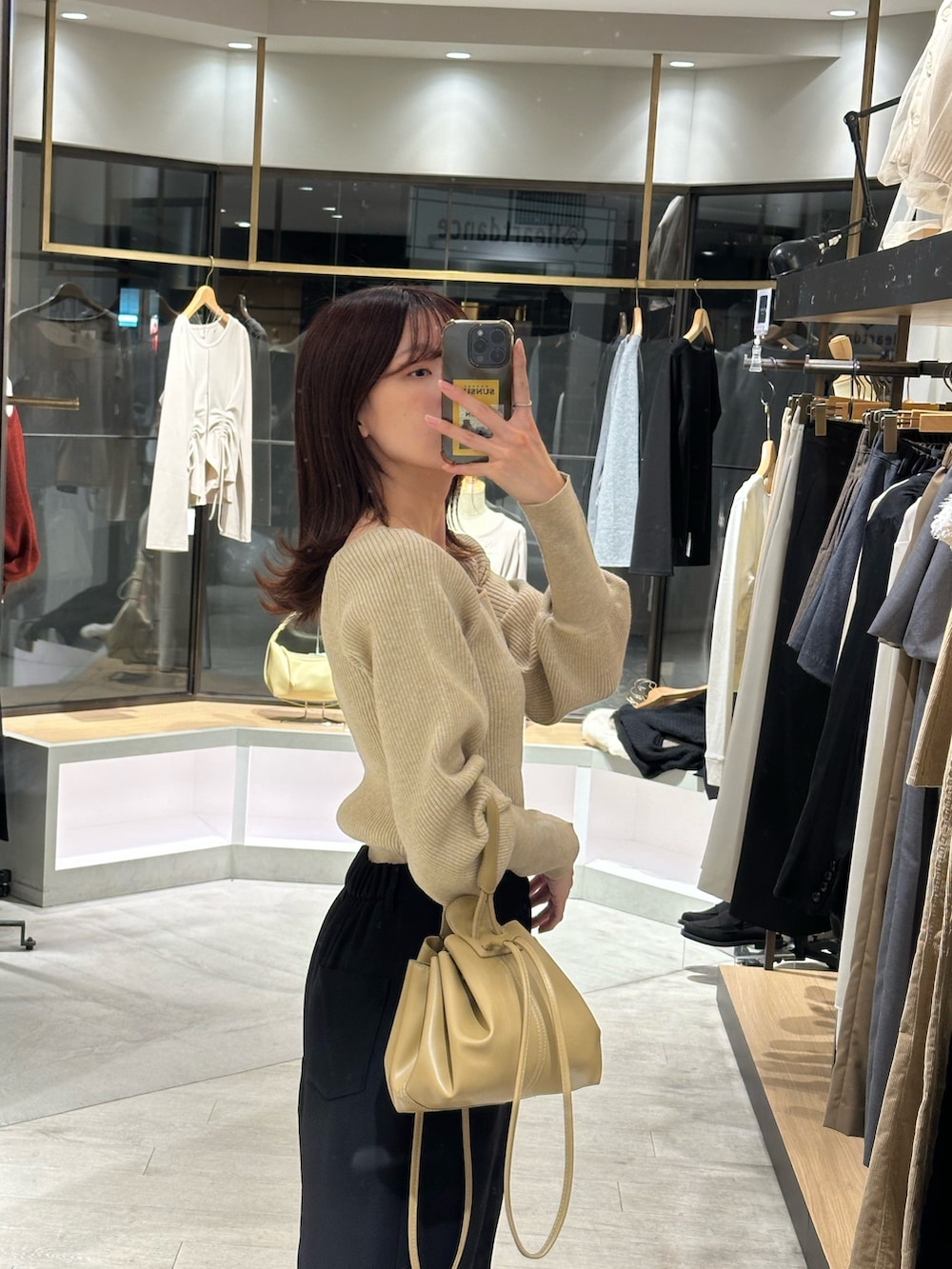 ベージュ系のニット/セーター、ブラック系のスカート、ブラック系のブーツを着用したレディースの秋コーディネートの3枚目の写真