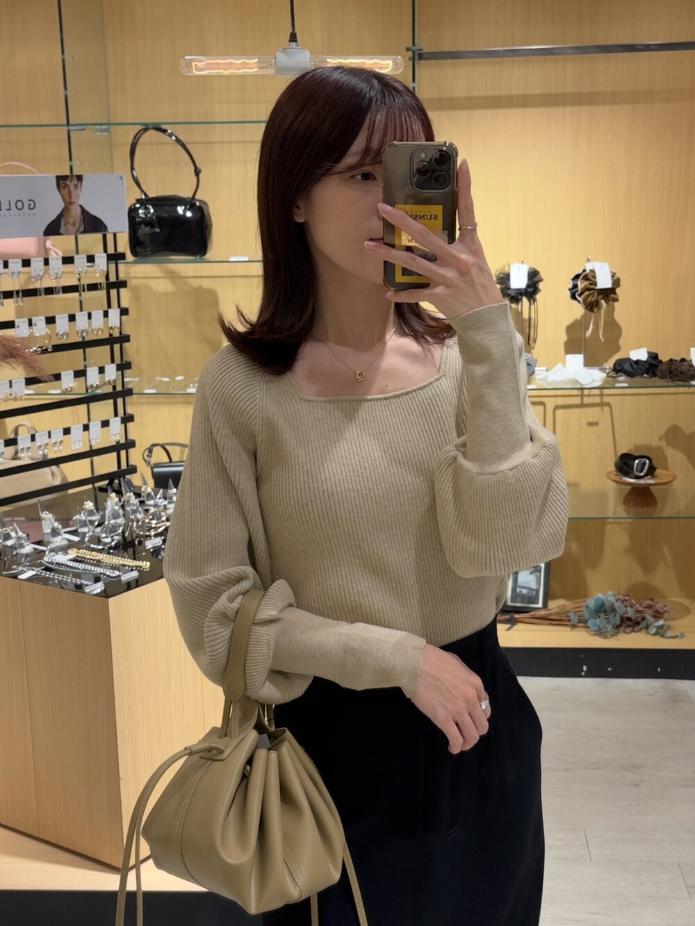 ベージュ系のニット/セーター、ブラック系のスカート、ブラック系のブーツを着用したレディースの秋コーディネートの2枚目の写真