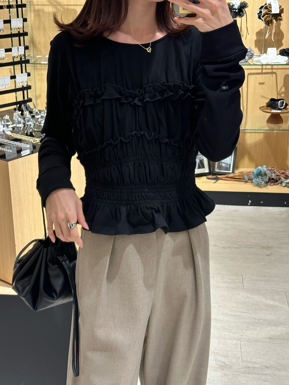 ブラック系のTシャツ/カットソー、ベージュ系のその他パンツ、ブラック系のショルダーバッグを着用したレディースの秋コーディネートの3枚目の写真