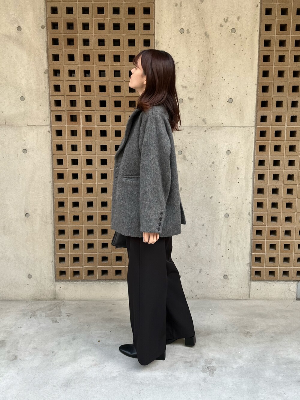 ブラック系のTシャツ/カットソー、グレー系のその他アウター、ブラック系のその他パンツを着用したレディースの冬コーディネートの2枚目の写真