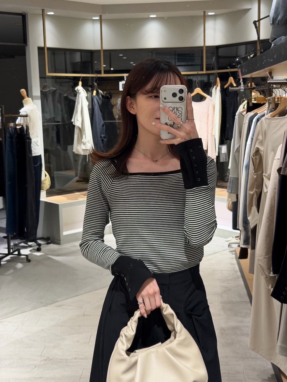 ブラック系のTシャツ/カットソー、ブラック系のスカート、ブラック系のパンプスを着用したレディースの春コーディネートの2枚目の写真