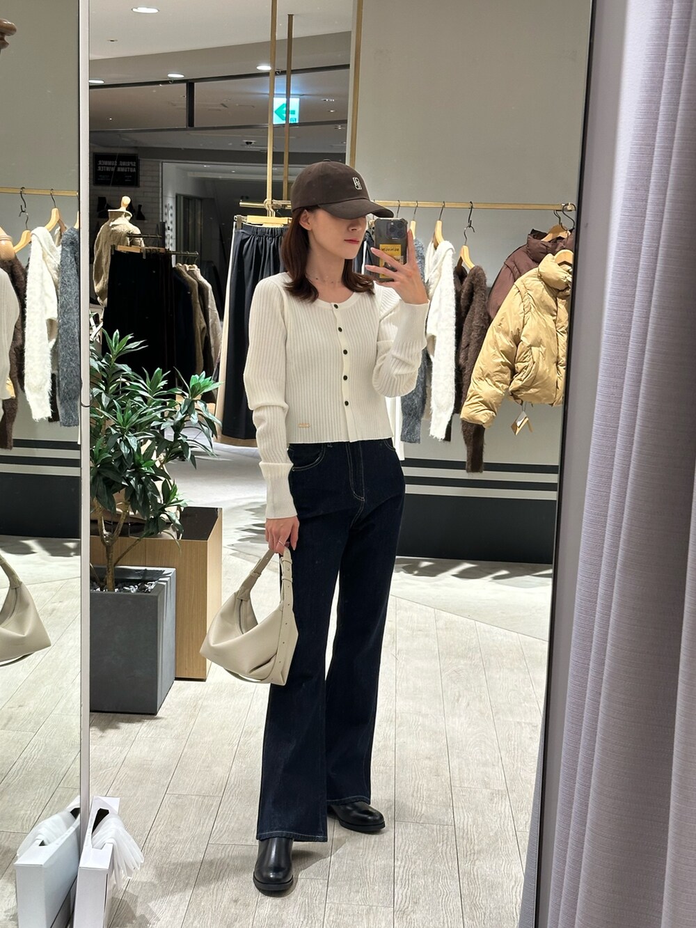 ホワイト系のその他アウター、ホワイト系のカーディガン/ボレロ、ブルー系のデニムパンツを着用したレディースの冬コーディネートの3枚目の写真