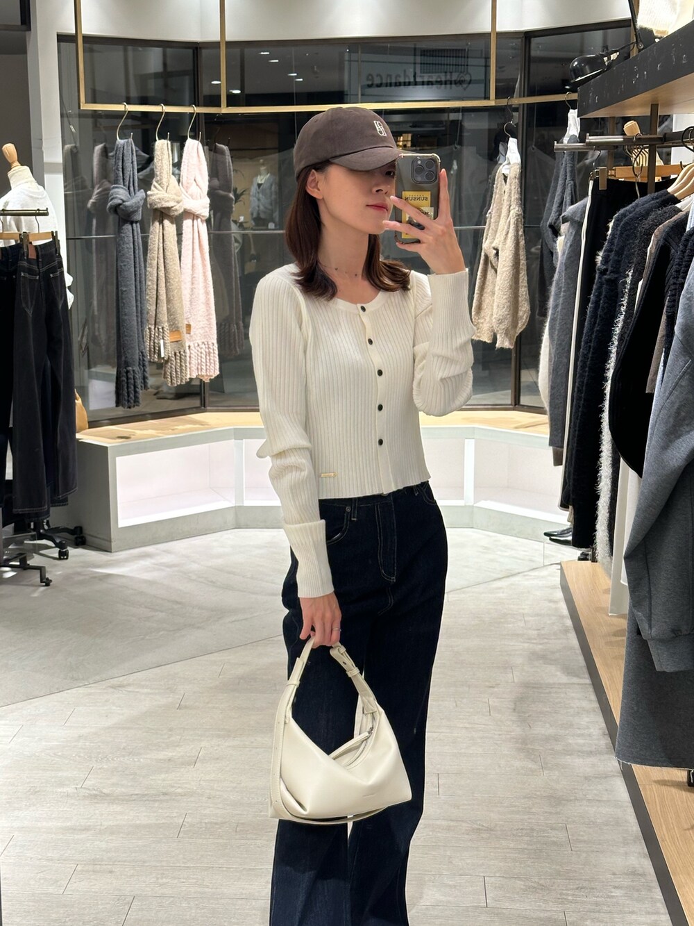 ホワイト系のその他アウター、ホワイト系のカーディガン/ボレロ、ブルー系のデニムパンツを着用したレディースの冬コーディネートの2枚目の写真