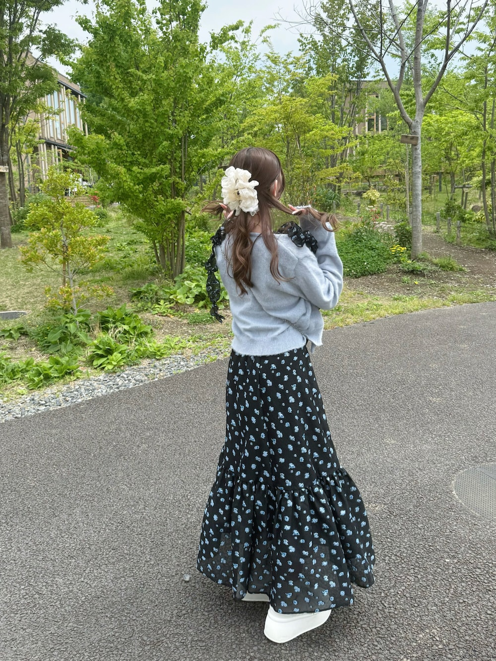 ホワイト系のスニーカー、ブラック系のワンピース、シルバー系のショルダーバッグを着用したレディースの春コーディネートの3枚目の写真