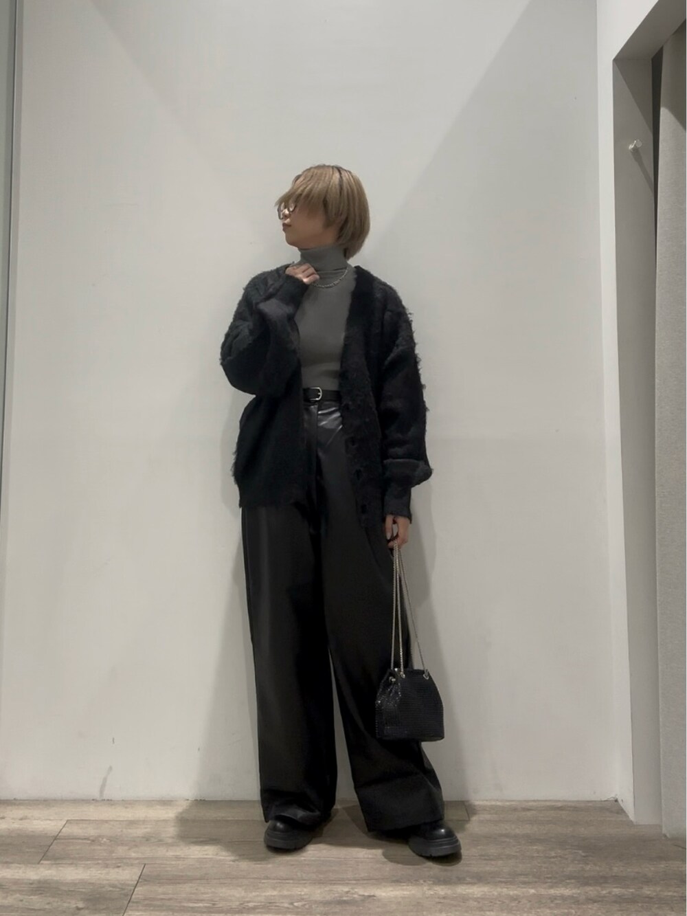 グレー系のニット/セーター、ブラック系のカーディガン/ボレロ、ブラック系のその他パンツを着用したレディースの冬コーディネートの3枚目の写真