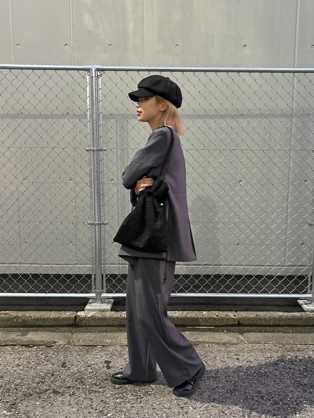 グレー系のスラックス、グレー系のテーラードジャケット、ブラック系のトートバッグを着用したレディースの秋コーディネートの2枚目の写真