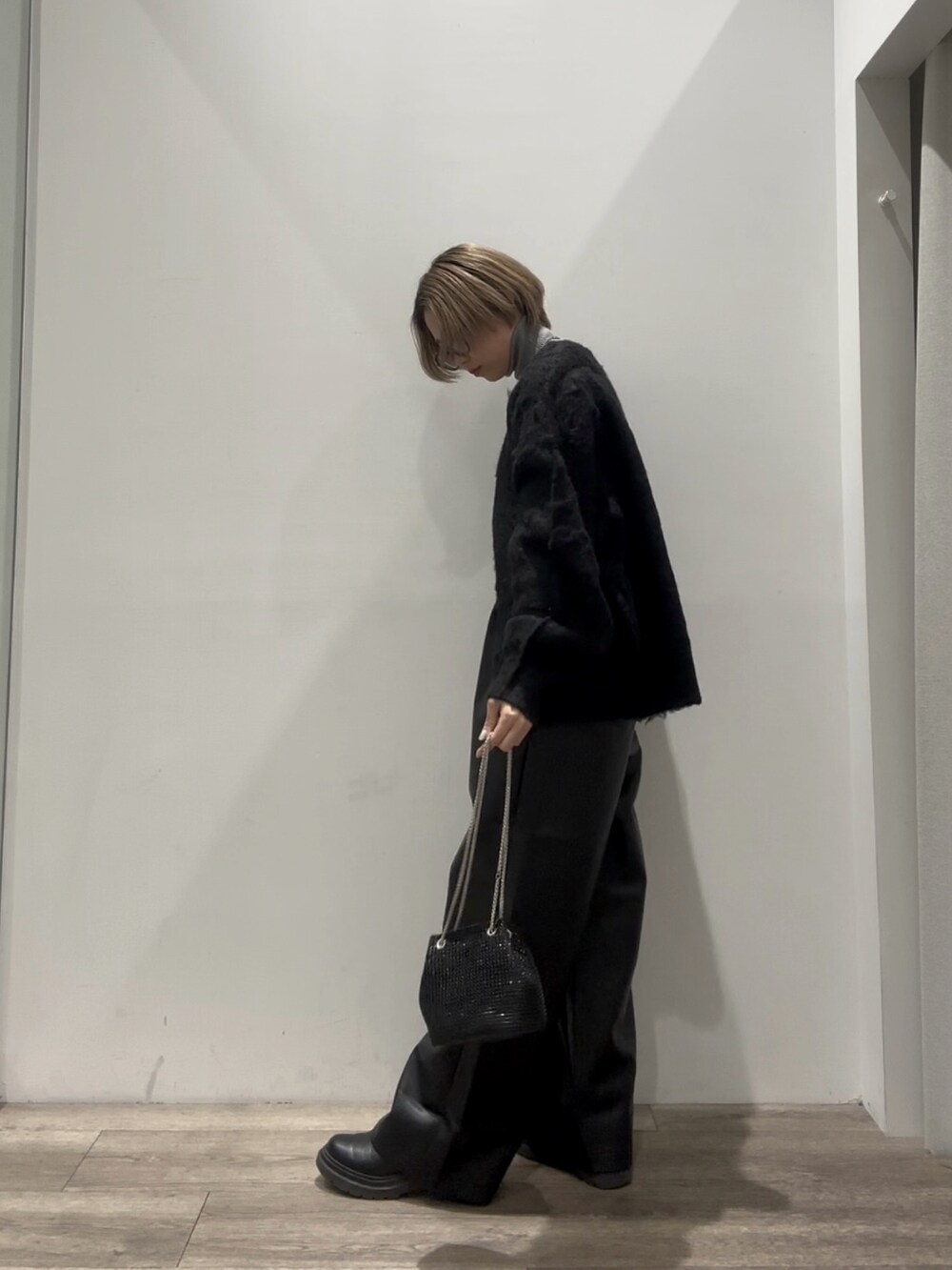 グレー系のニット/セーター、ブラック系のカーディガン/ボレロ、ブラック系のその他パンツを着用したレディースの冬コーディネートの2枚目の写真