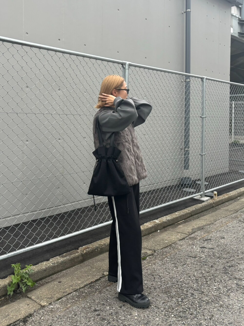 グレー系のベスト、グレー系のニット/セーター、ブラック系のトートバッグを着用したレディースの秋コーディネートの4枚目の写真