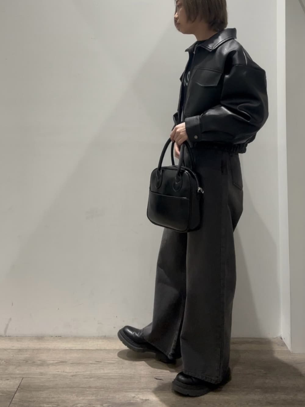 「レザージャケット、ショート丈、ショート丈ブルゾン、ワイドデニム、ワイドデニムパンツ、ブラックデニム、ブラックニット、ボストンバック、レザーブーツ 黒、レザーブーツ」｜「COLONY 2139のフェイクレザーショートブルゾン（ブルゾン、ブラック系）」を使った、tomooookaさん（骨格ウェーブ・レディース・157cm）の冬コーディネートの2枚目の写真