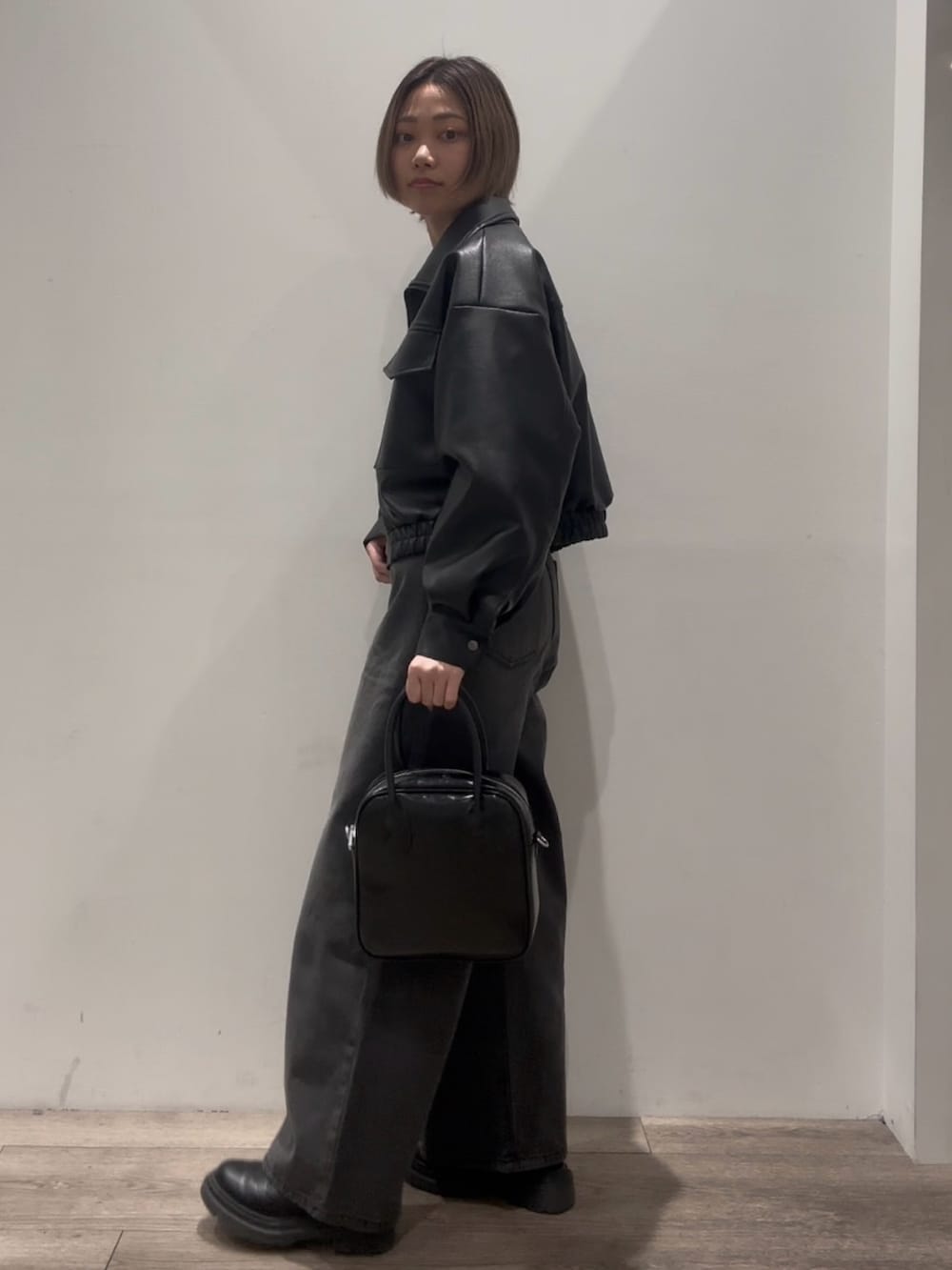 「レザージャケット、ショート丈、ショート丈ブルゾン、ワイドデニム、ワイドデニムパンツ、ブラックデニム、ブラックニット、ボストンバック、レザーブーツ 黒、レザーブーツ」｜「COLONY 2139のフェイクレザーショートブルゾン（ブルゾン、ブラック系）」を使った、tomooookaさん（骨格ウェーブ・レディース・157cm）の冬コーディネートの4枚目の写真