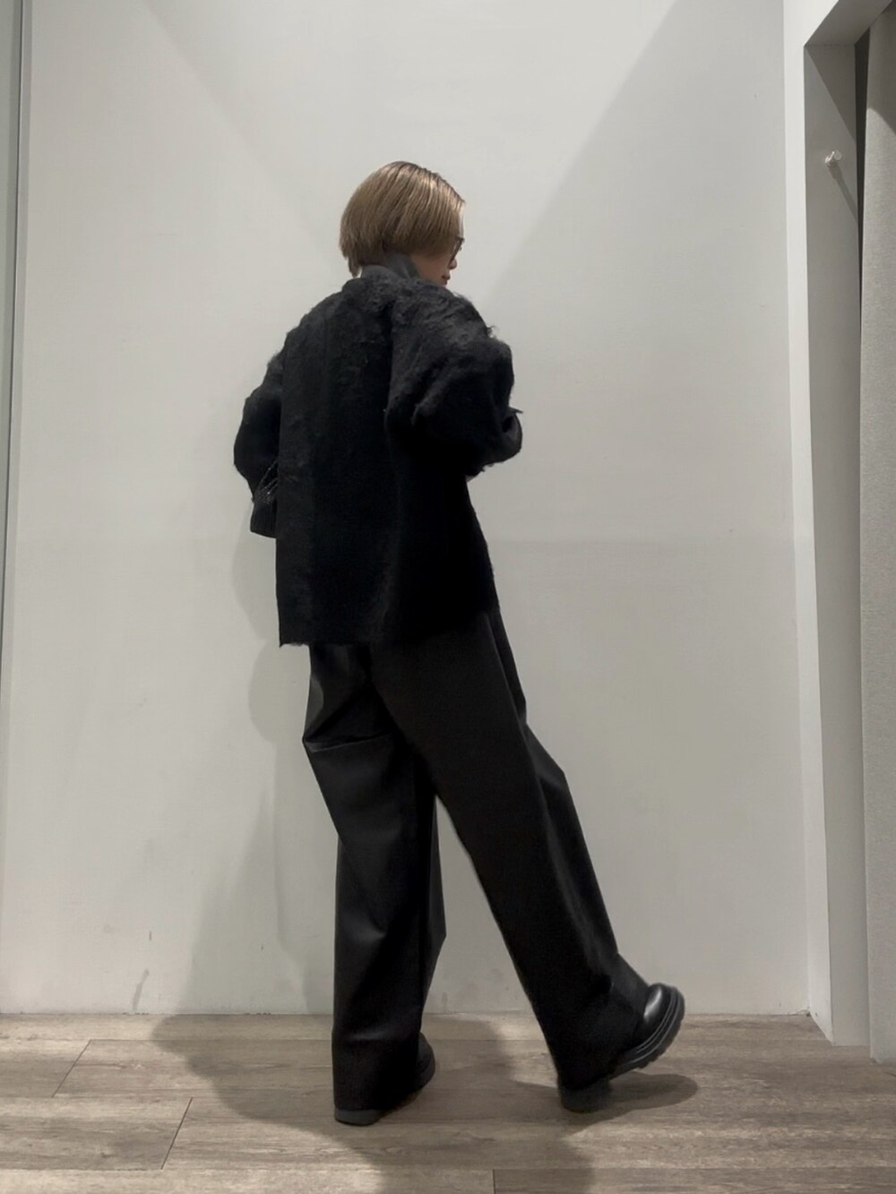 グレー系のニット/セーター、ブラック系のカーディガン/ボレロ、ブラック系のその他パンツを着用したレディースの冬コーディネートの4枚目の写真