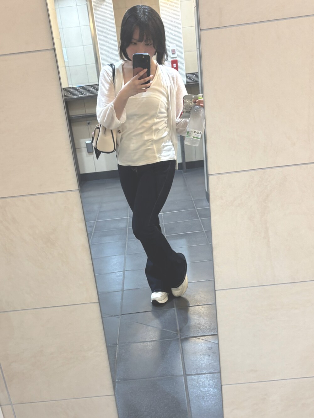 ホワイト系のタンクトップ、ブルー系のデニムパンツを着用したレディースの夏コーディネートの3枚目の写真