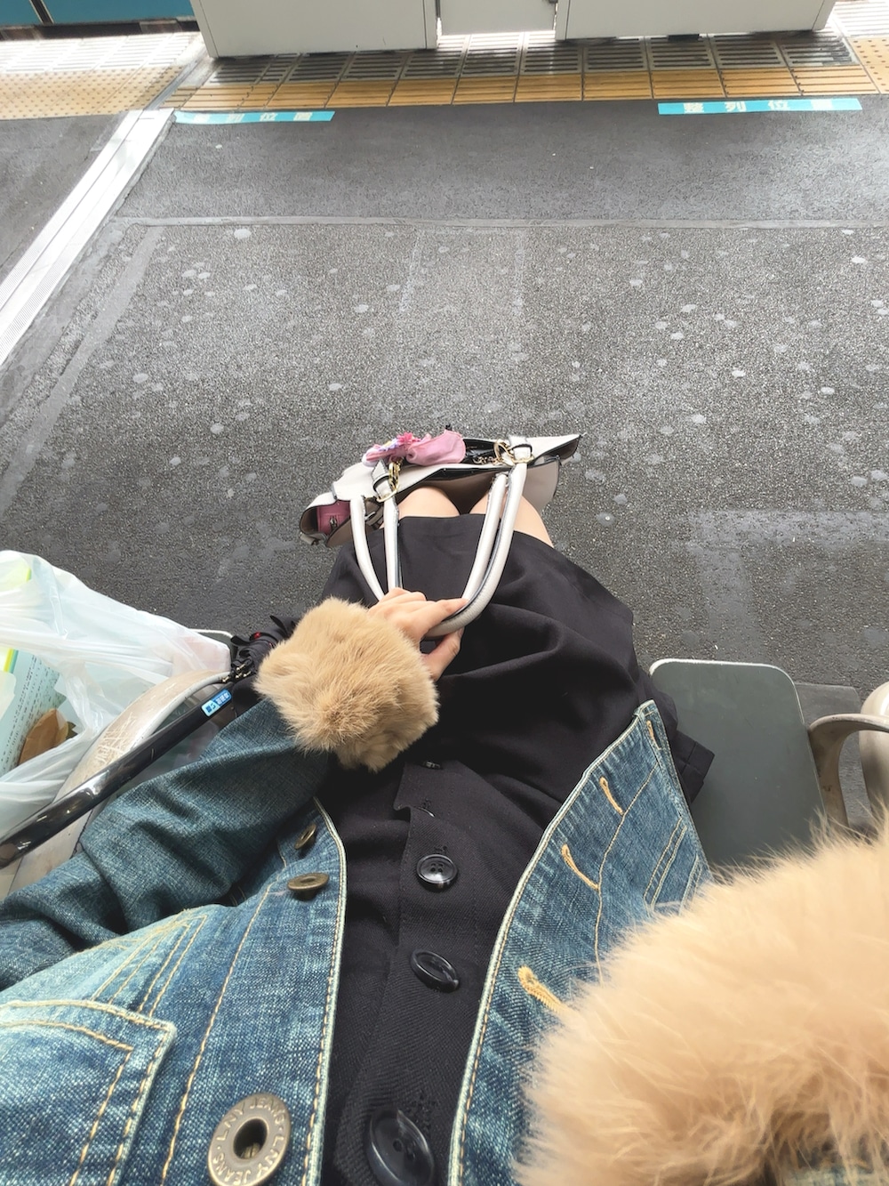 ブルー系のデニムジャケット、ブラック系のワンピース、グレー系のニット/セーターを着用したレディースの秋コーディネートの3枚目の写真