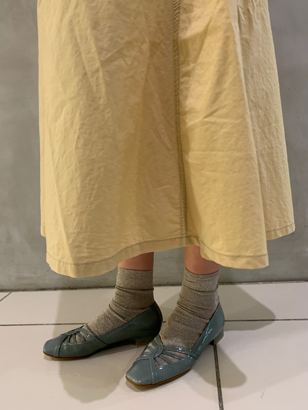 グリーン系のパンプスを着用したレディースの春コーディネートの2枚目の写真