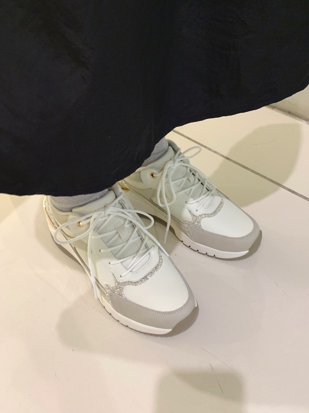 ホワイト系のスニーカーを着用したレディースの春コーディネートの2枚目の写真