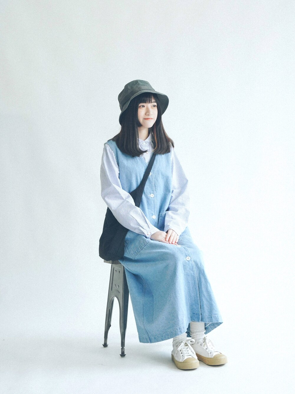 ブルー系のデニムスカートを着用したレディースの春コーディネートの2枚目の写真