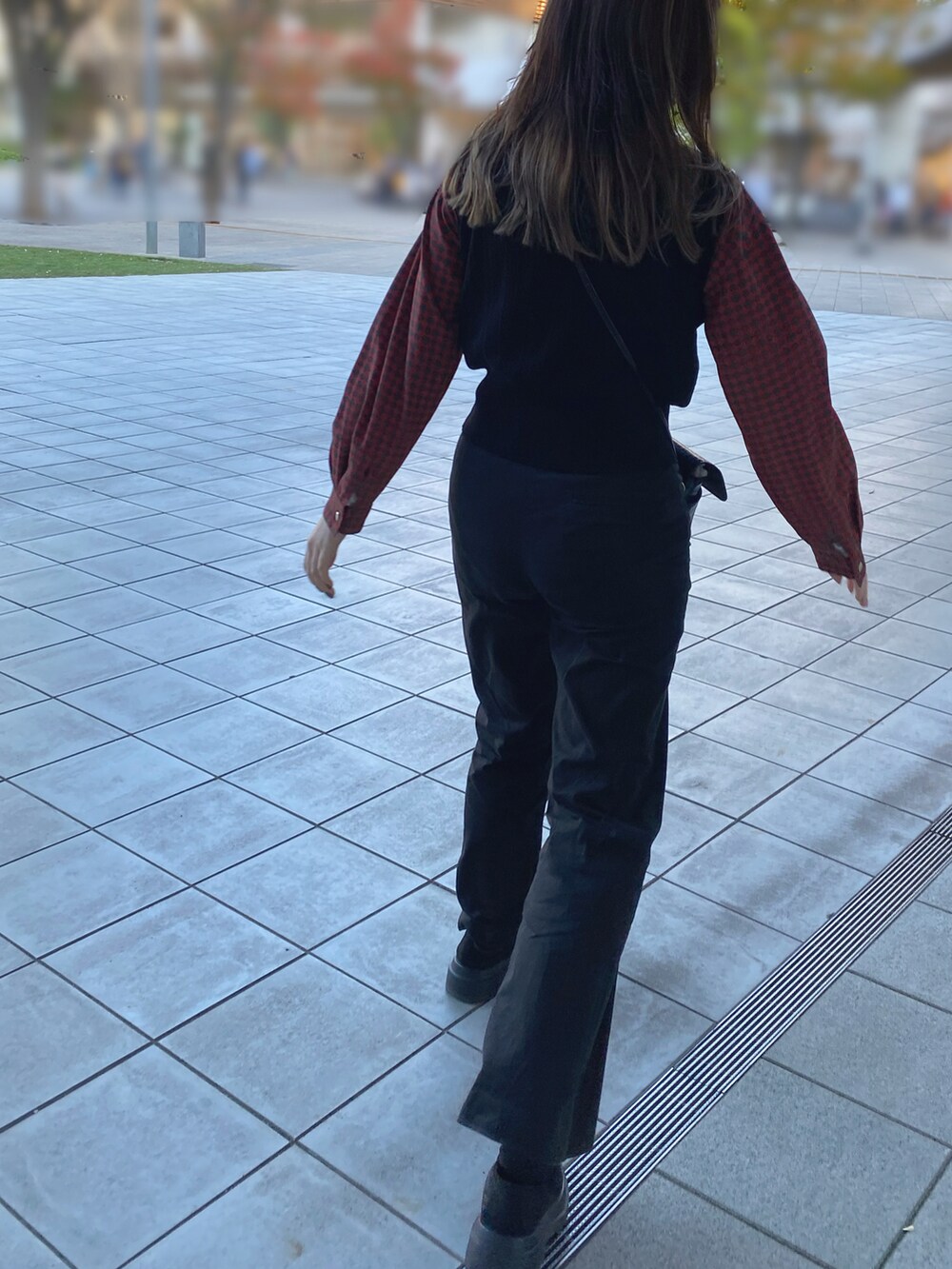 ブラック系のベストを着用したレディースの秋コーディネートの2枚目の写真