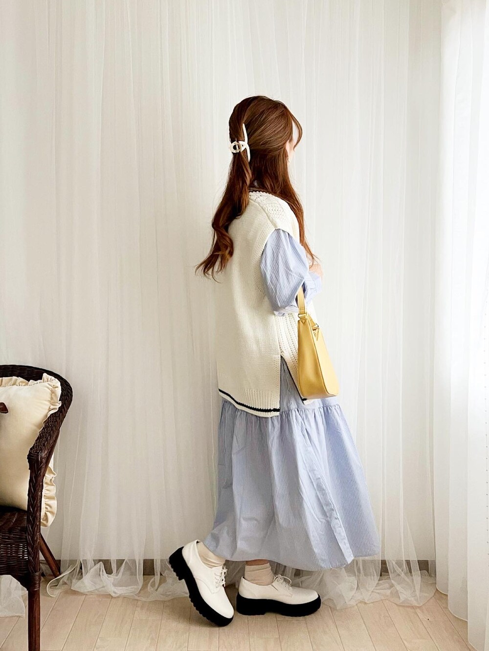 ホワイト系のベスト、ブルー系のシャツワンピース、イエロー系のショルダーバッグを着用したレディースの春コーディネートの4枚目の写真